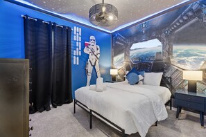 A bedroom with a bed, a nightstand, a wall mural, and a ceiling fan. - 8br Disney-area Resort Home, Private Pool, Game Room Sleeps 17,lazy River-7054 8 Bedroom Home (Davenport)