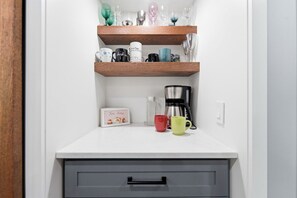 A kitchen with wooden shelves, a coffee maker, and a tea time sign. - Room for ten in the heart of Bayfield village (Bayfield)