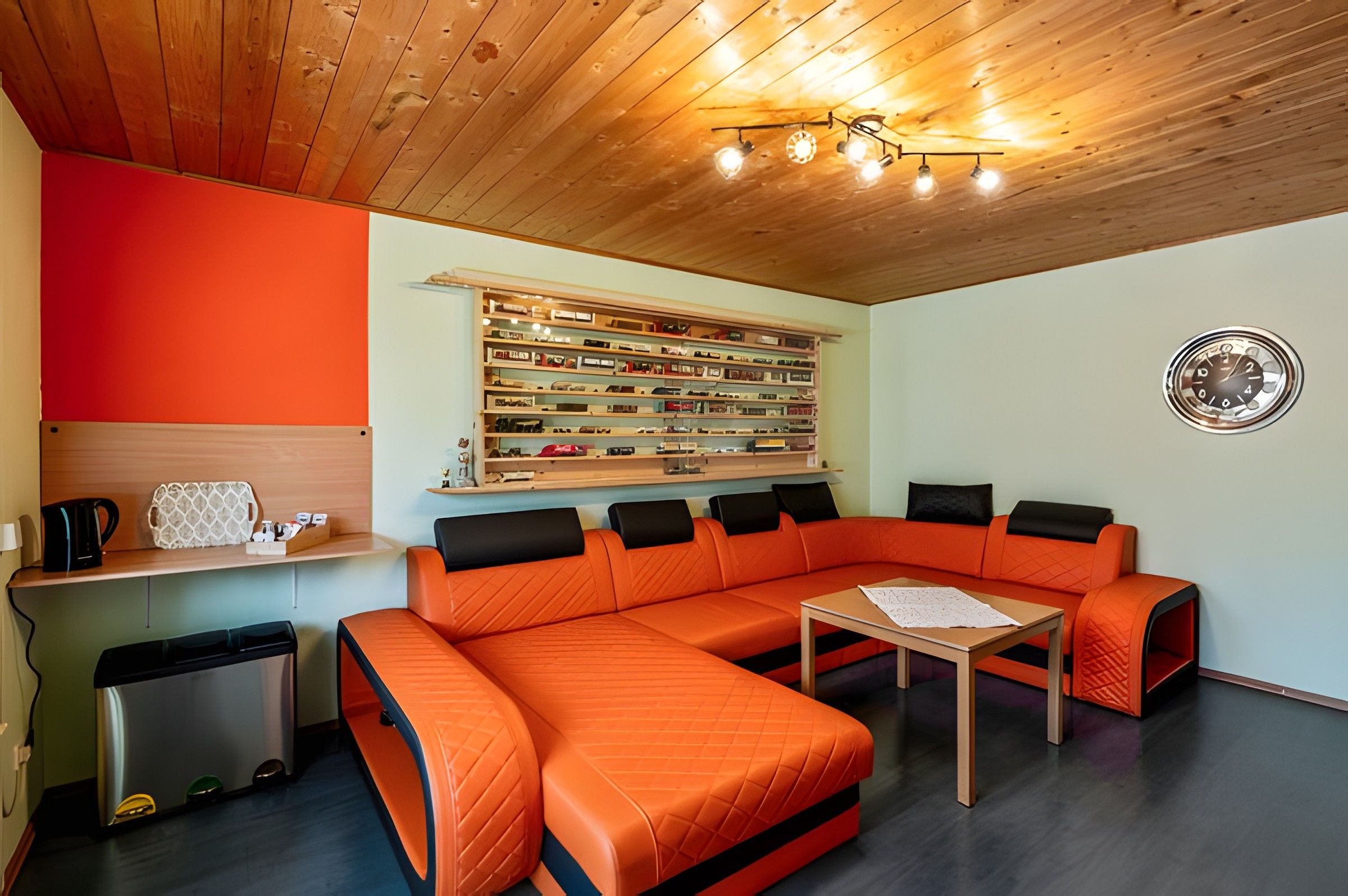 Uma sala de estar moderna com sofá seccional, mesa de centro e um painel para exposição de sapatos.
