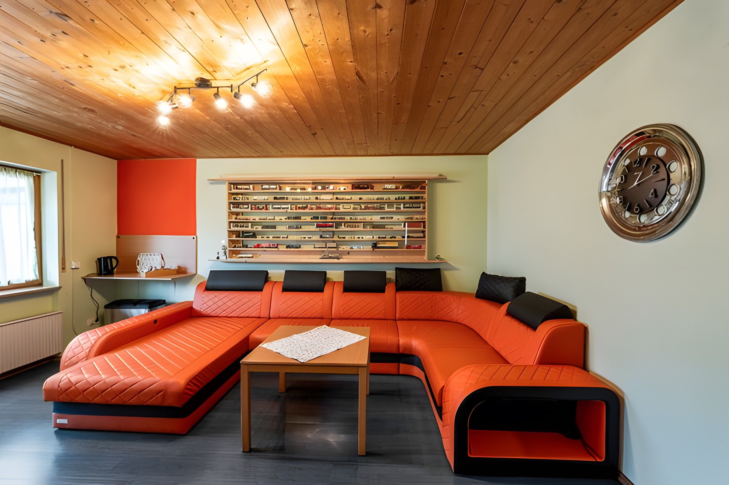 Uma sala de estar moderna com um sofá seccional, uma mesa de centro e uma estante.