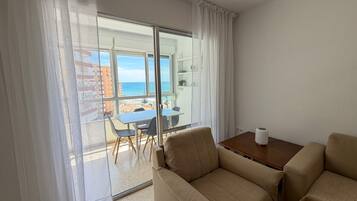 Een hotelkamer met een balkon, een tafel en twee stoelen.