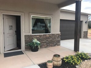 A residential building with a stone facade, a garage door, and a door with a no smoking and no pets sign. - Downtown Kanab Hideaway | Walk to Shops & Dining (Kanab)