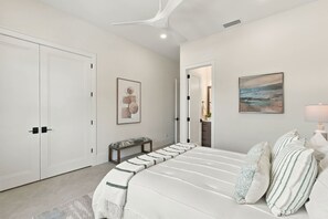 A bedroom with a bed, a bench, a door, and a painting on the wall. - Luxury Home - Close to Beach -Saltwater Pool & Spa (Naples)