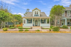 A two-story house with a front porch, a small garden, and a street view. - Olivia Beach Beauty; Hot Tub, Grill, Near Beach Access (Lincoln City)