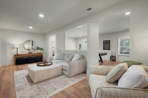 A modern living room with a sofa set, a coffee table, and a side table with a lamp.