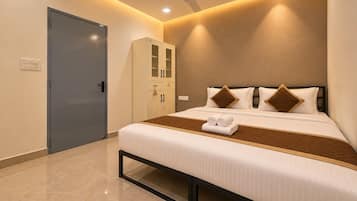 A hotel room with a bed, a wardrobe, a ceiling fan, and recessed lighting.