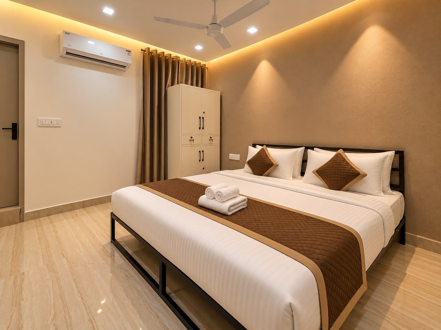 Habitación de hotel con cama, armario, aire acondicionado, ventilador de techo y puerta de baño.