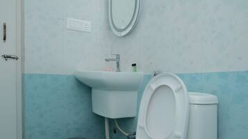 Un baño con inodoro, lavabo y espejo.
