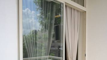 Une pièce dotée d’une porte-fenêtre coulissante donnant sur un balcon extérieur.