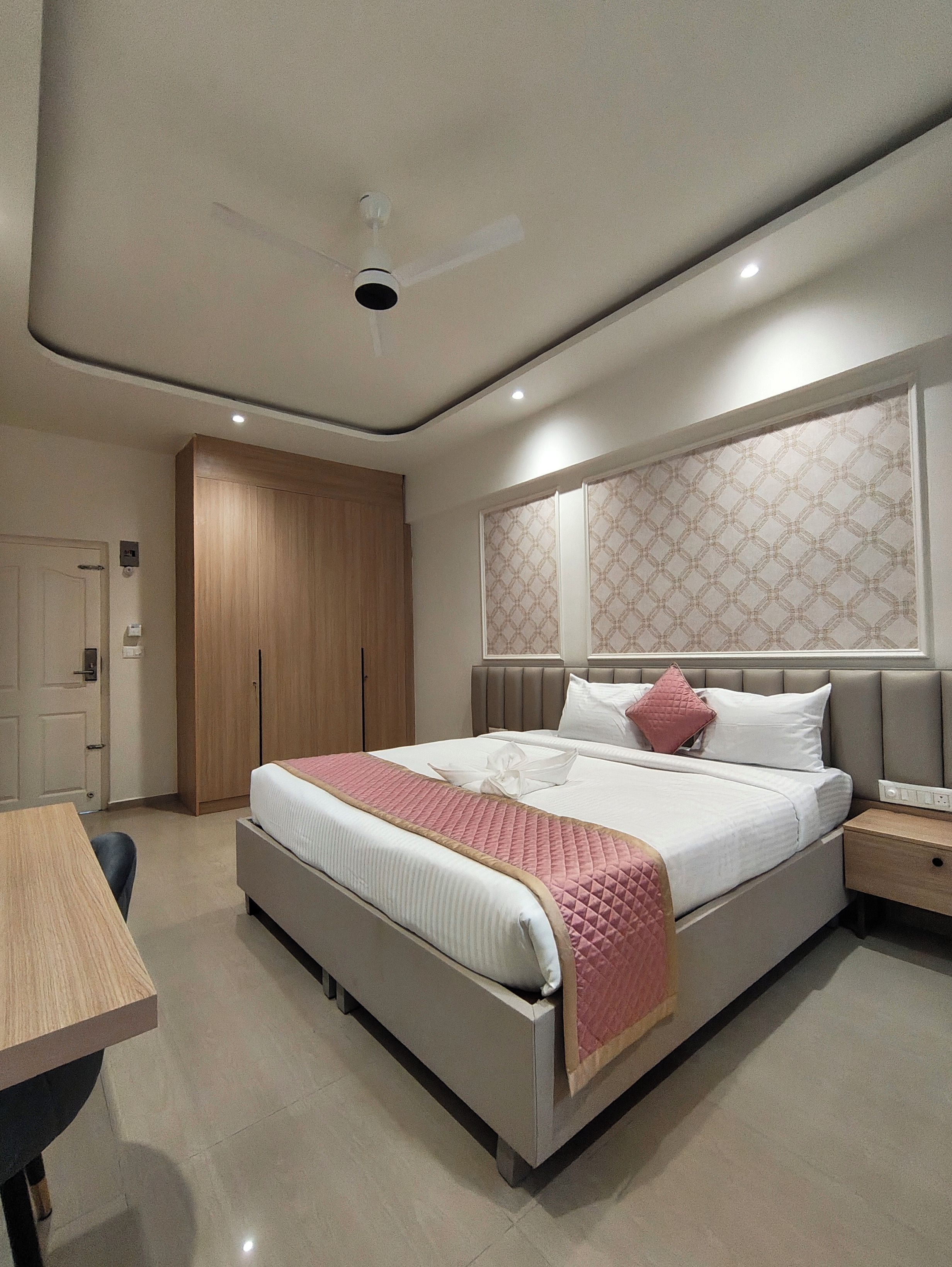 Una camera da letto moderna con un letto, un comodino, un armadio e una ventola a soffitto.