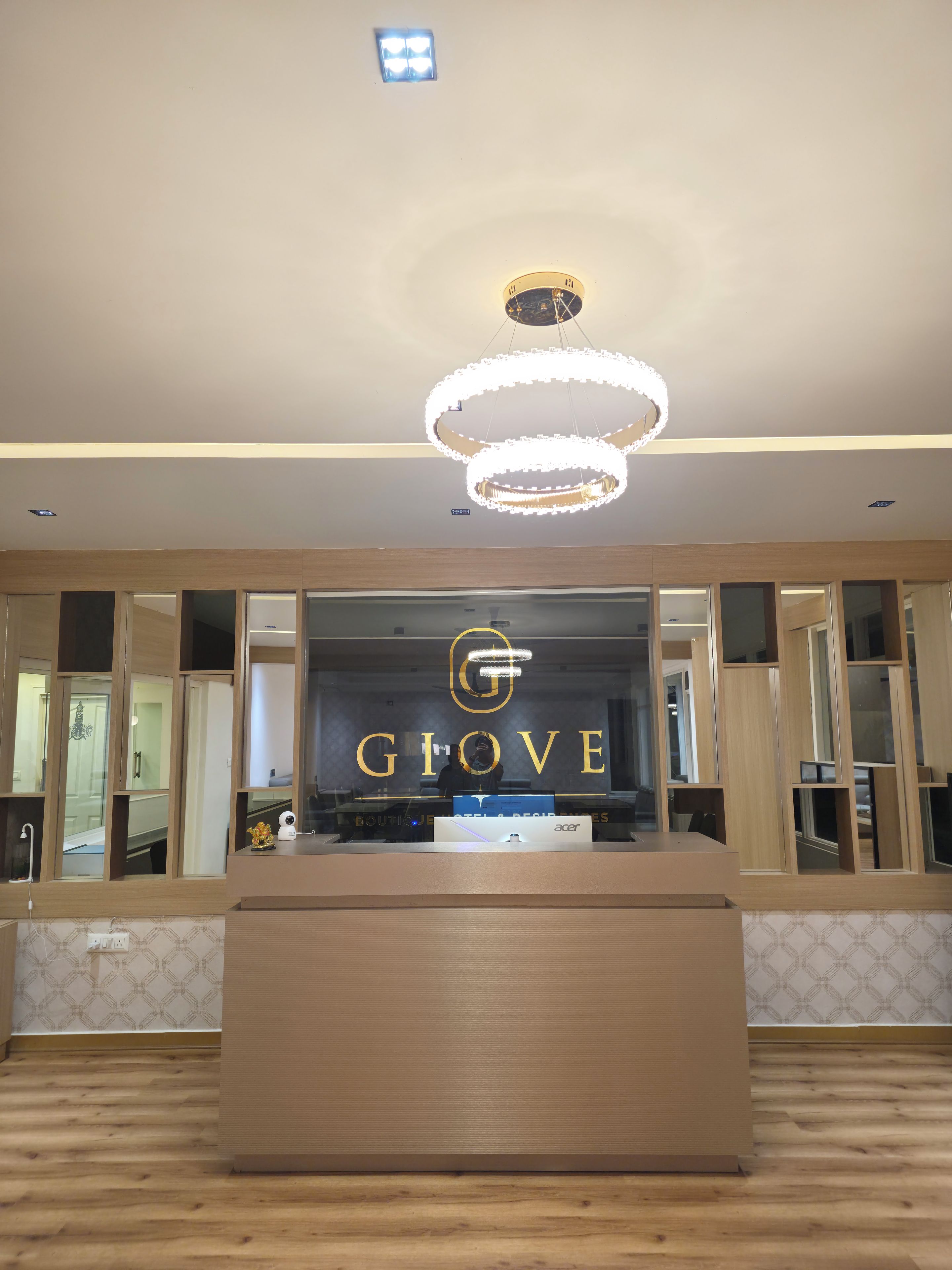 Un mostrador de recepción de hotel con diseño moderno, que muestra un logotipo y el nombre 'GLOVE' de forma destacada.