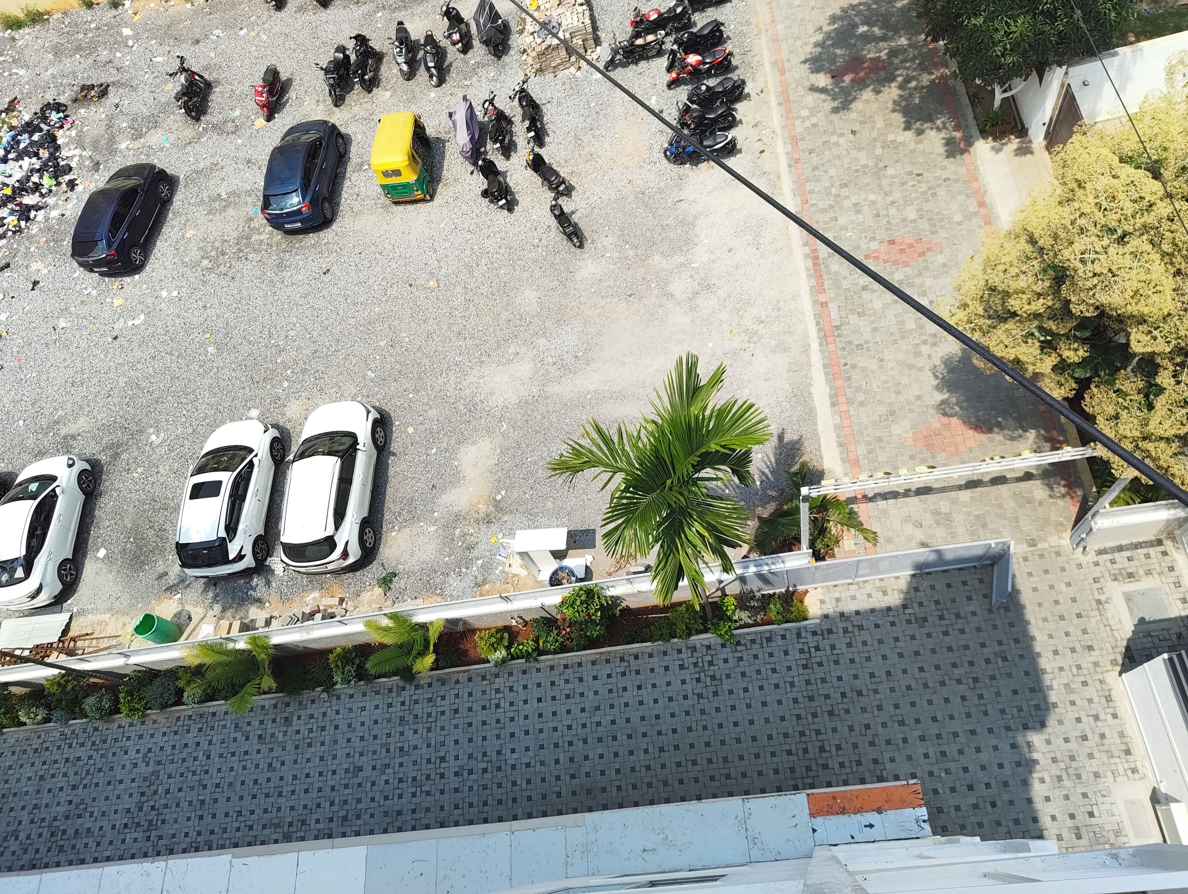 An aerial view of a parking area with multiple cars and motorcycles.