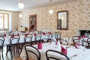 A dining area with multiple tables set for a meal, a wooden cabinet, and a mirror on the wall. - Hotel Ofenhorn (Binn)