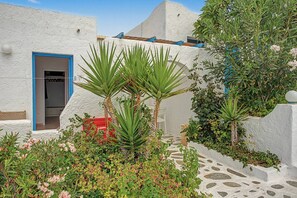 A courtyard with white walls, a blue door, and a stone pathway. - Apartment 'Bangalow 1' with Sea View, Wi-Fi and Air Conditioning (Αρκάσα)