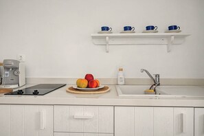 Eine Küche mit einer Bosch-Kaffeemaschine, einem Tablet, einer Obstschale, einem Spülbecken und einem Seifenspender.