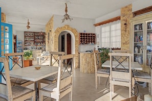 A rustic interior with wooden furniture, a bar area, and a bookshelf. - Apartment 'Pool Suite 5' with Sea View, Wi-Fi and Air Conditioning (Αρκάσα)