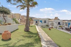 A courtyard with a palm tree, outdoor seating, and a pathway. - Apartment 'Pool Suite 8' with Shared Pool and Balcony (Αρκάσα)