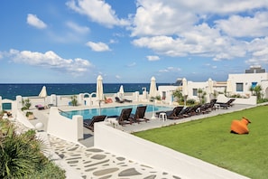 A poolside area with lounge chairs and umbrellas, overlooking the sea. - Apartment 'Pool Suite 8' with Shared Pool and Balcony (Αρκάσα)