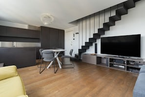 A modern living space with a kitchen, dining area, and a staircase leading to a second floor. - A modern and bright 50 sqm one-bedroom apartment with a terrace, suitable for two guests and located near the San Siro Stadium. Situated on the eighth floor of a building (with elevator —though NOT suitable for people with disabilities due to a few ste (Milan)