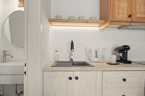 A modern kitchen with a sink, faucet, coffee maker, and a shelf with cups. - Studio Apartment 'Thalassa Suite 4' with Sea View and Shared Pool (Αρκάσα)