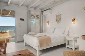 A bedroom with a bed, bedside tables, a view of the sea, and a macrame wall decoration. - Studio Apartment 'Thalassa Suite 6' with Sea View and Shared Pool (Αρκάσα)