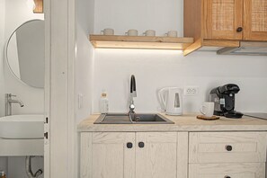 A modern kitchen with a sink, coffee maker, and cabinets. - Studio Apartment 'Thalassa Suite 6' with Sea View and Shared Pool (Αρκάσα)