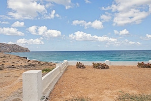 A coastal landscape with a rocky terrain, a white wall, and a view of the sea. - Studio Apartment 'Thalassa Suite 6' with Sea View and Shared Pool (Αρκάσα)