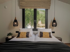 A bed with two pillows, a bedside plant, and a window with a view of greenery. - Villa Verde Zante - Three Bedroom Villa, Sleeps 7 (Kallithea)
