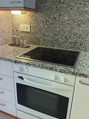 A kitchen with a granite countertop, a built-in oven, and a stainless steel sink. - Luxury Penthouse with Terrace, Pool, and Views (Sant Cugat del Vallès)