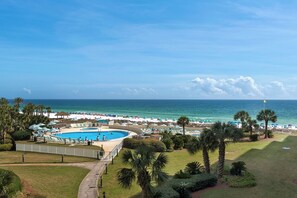 A resort with a pool, beach, and palm trees. - Edgewater Beach Condo 0407 (Destin)
