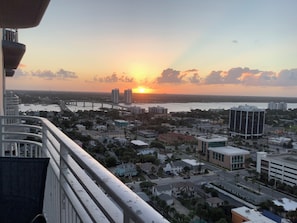 A cityscape with a sunset over a body of water, featuring a bridge, buildings, and a residential area. - Spacious condo Ocean Walk Resort with lazy river (Daytona Beach)