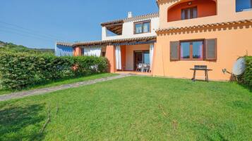 A two-story house with a well-maintained lawn and a patio area.