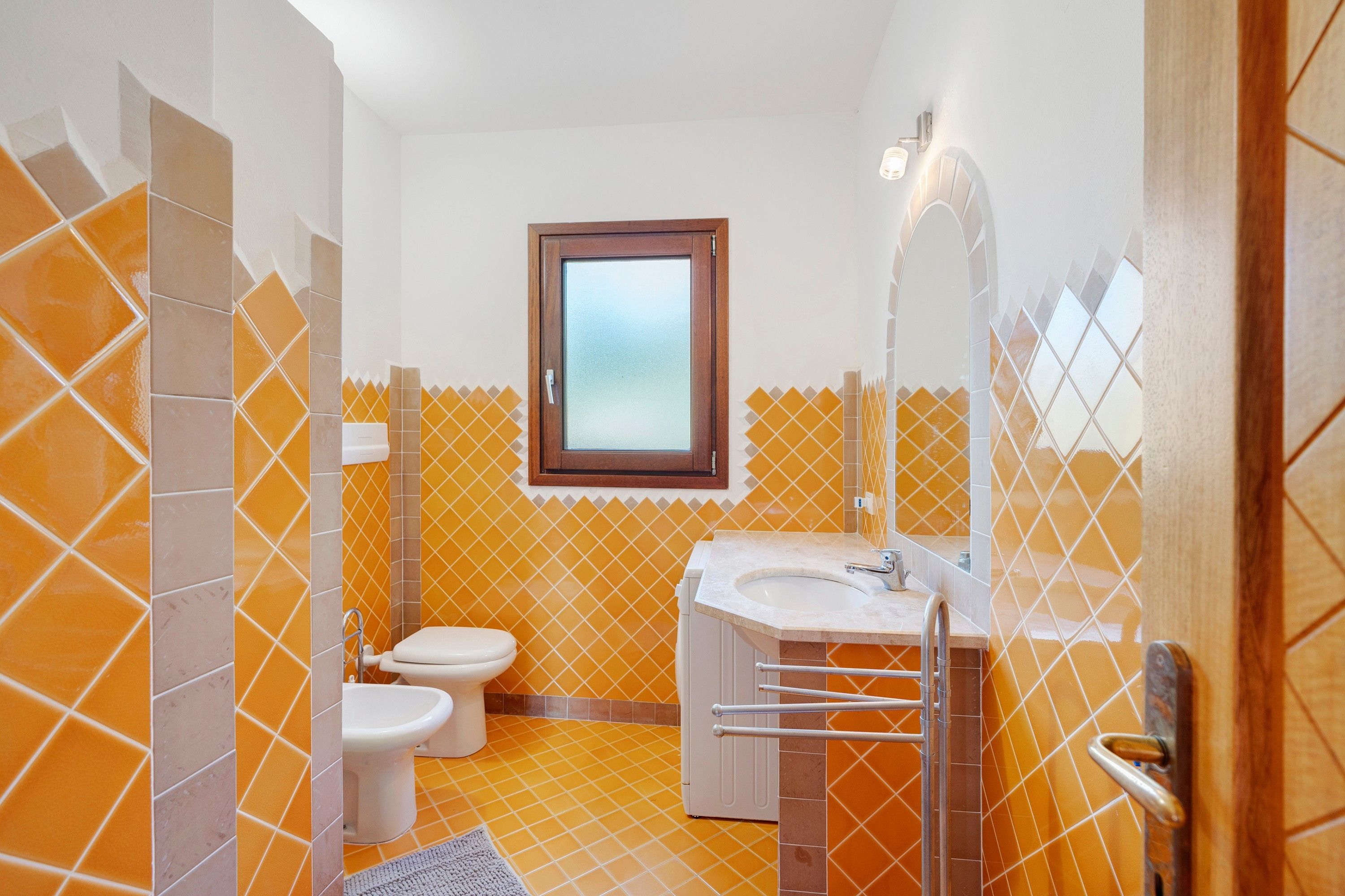 A bathroom with a toilet, bidet, and sink.