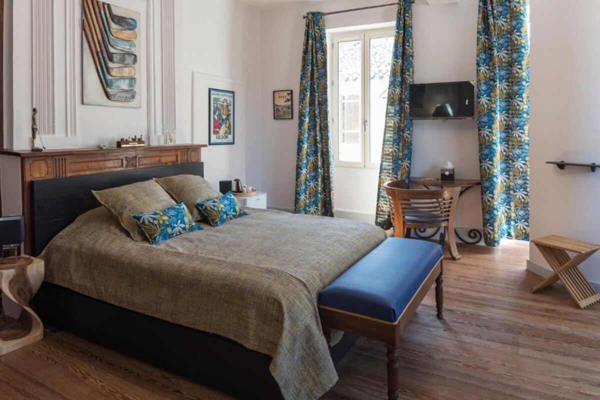 Ein Schlafzimmer mit Bett, Schreibtisch, Stuhl und Fernseher.