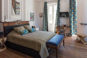 Ein Schlafzimmer mit Bett, Schreibtisch, Stuhl und Fernseher.