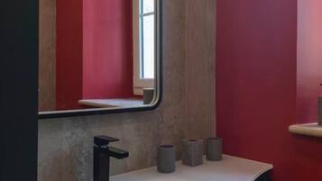 A bathroom with a white sink, a black faucet, and a mirror.