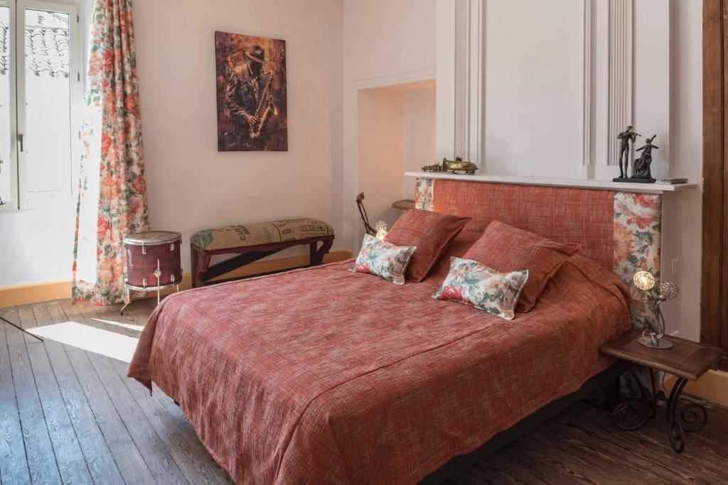 Un dormitorio con una cama grande, un aparador, un espejo y una ventana con cortinas.