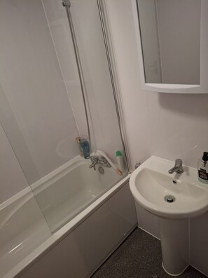 Un baño con bañera, lavabo y espejo.