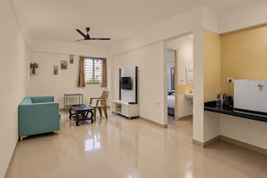 Una cocina moderna con refrigerador, estufa y pileta. Cuenta con un comedor con mesa y sillas.