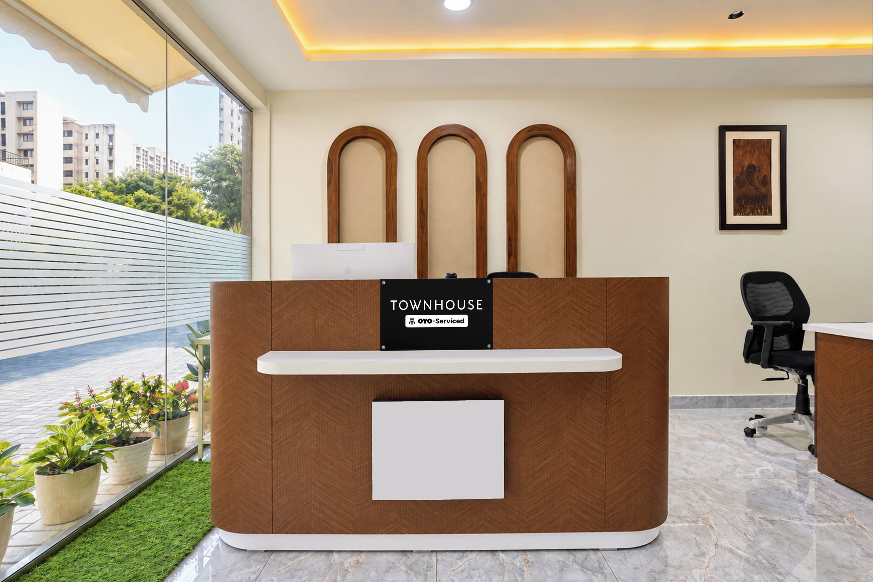Una mesa de recepción con un cartel que dice 'TOWNHOUSE' y 'oyo-serviced'.