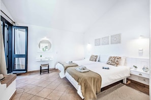 A hotel room with a bed, bedside tables, a mirror, and a view through a door. - Villa Levante - Two Bedroom Villa, Sleeps 4 (Albufeira)
