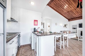 A modern kitchen with a central island, white cabinetry, and a wooden ceiling. - Villa Levante - Two Bedroom Villa, Sleeps 4 (Albufeira)