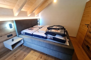 Een knus slaapkamer met een bed, nachtkastje en een klein bureau.