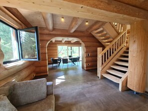 A wooden interior with a staircase, a dining area, and a sofa. - Chalet Waldblick by Globalimmoservice (Ebene Reichenau)