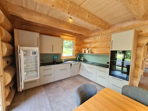Een kleine keuken met houten kastjes, een ingebouwde oven en een raam dat voor natuurlijk licht zorgt.