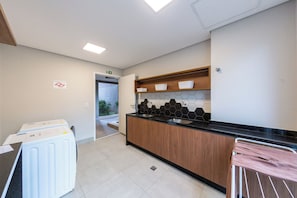 Eine moderne Küche mit schwarzem Arbeitsplatz, Holzschränken und Blick auf einen Garten.