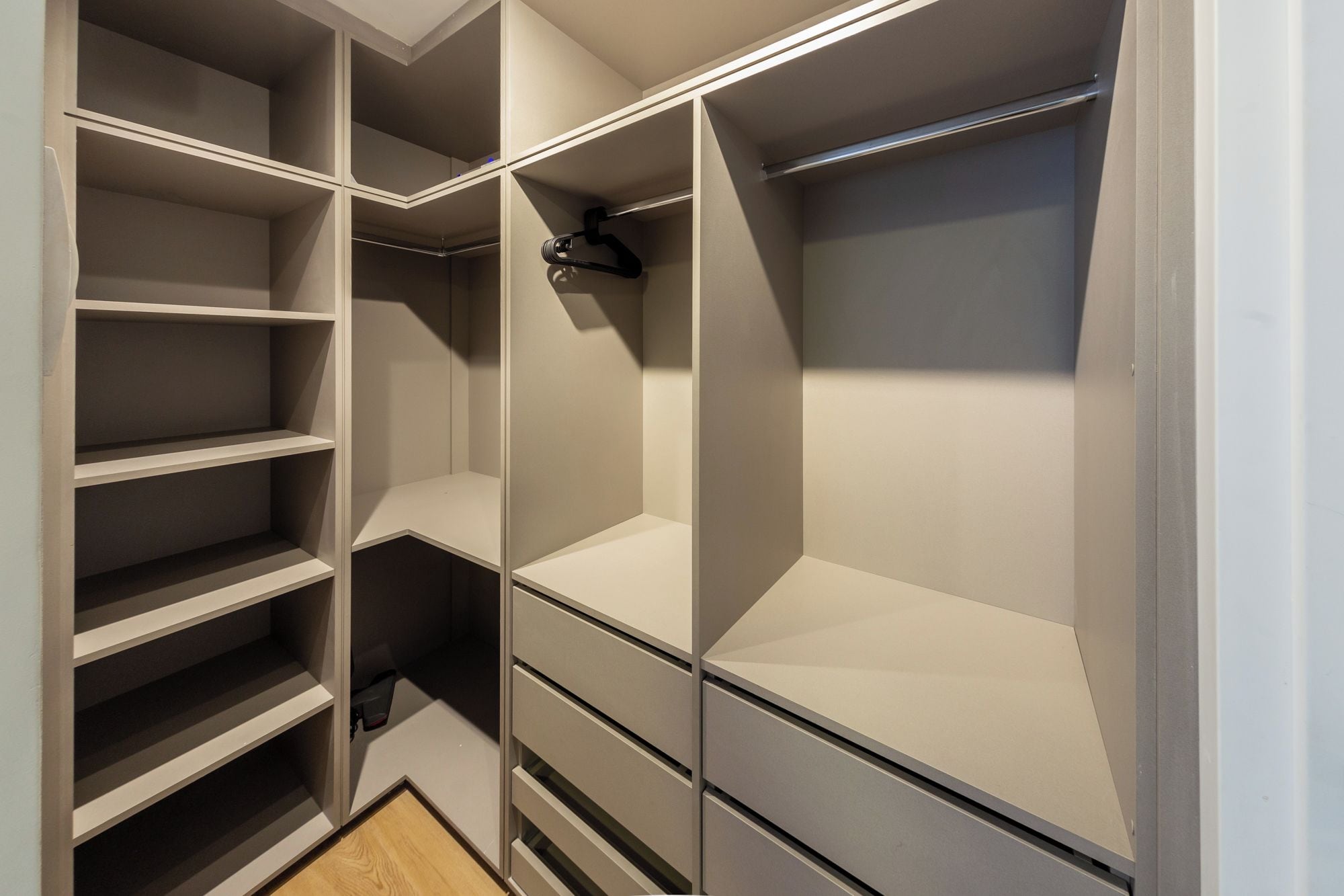 A walk-in closet with multiple shelves and drawers.