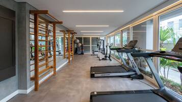 A modern gym with treadmills, exercise equipment, and large windows.
