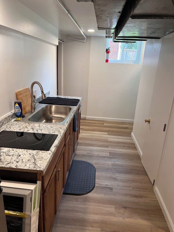 A modern kitchen with a granite countertop, stainless steel sink, and a built-in stove.