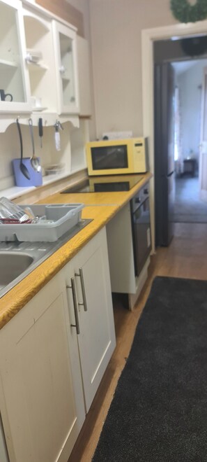 A kitchen with a microwave, a sink, and cabinets.